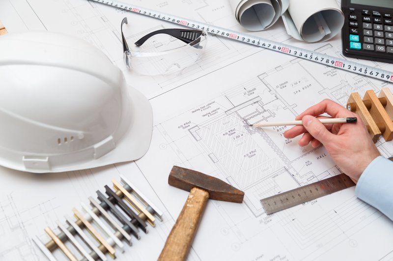 Architectes de concept ou ingénieur tenant un crayon pointant des architectes d'équipement. Sur le bureau avec un plan au bureau