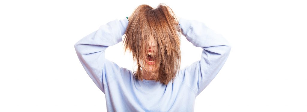 白い背景の上の彼女の髪で遊んでポーズをとっている女の子