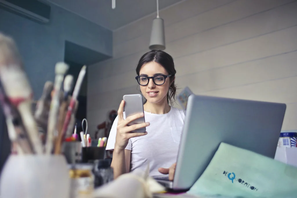 Persoană care zâmbește uitându-se la un telefon