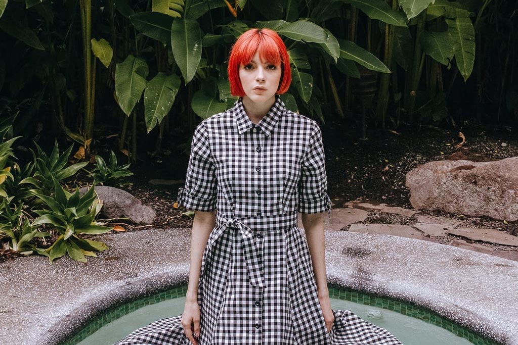 穿著格子裙、紅頭髮的人站在游泳池裡