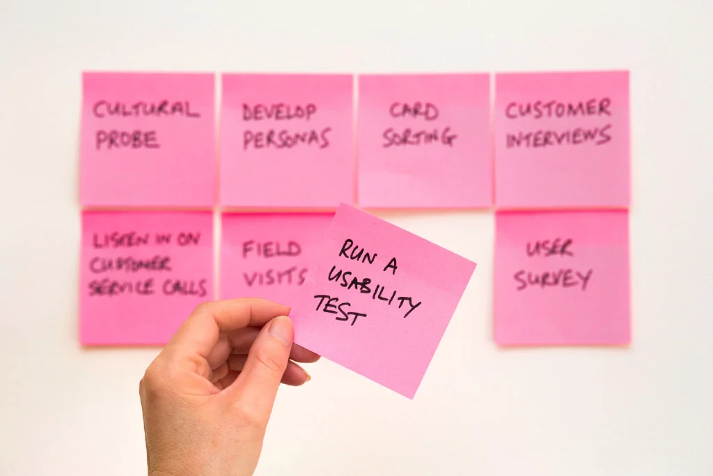 Note adesive rosa su un muro che dicono di eseguire un test di usabilità