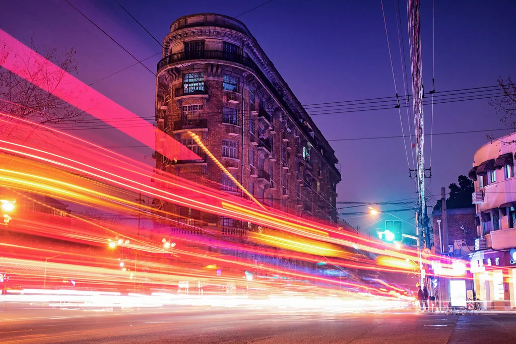 Una strada di notte con le auto che passano veloci