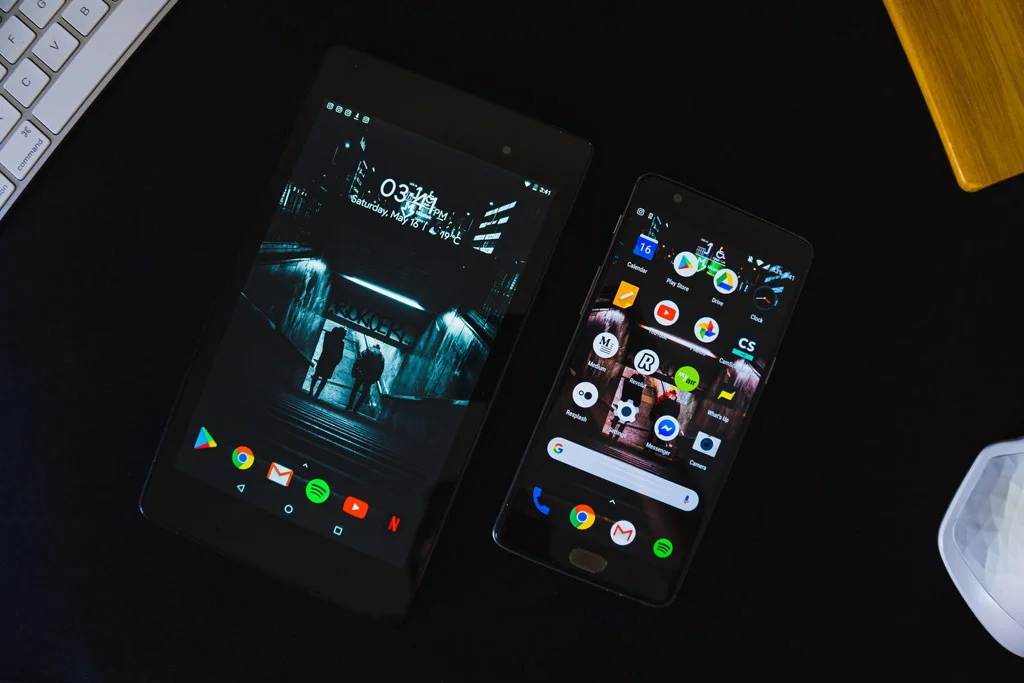 Siyah bir masada oturan tablet ve telefon