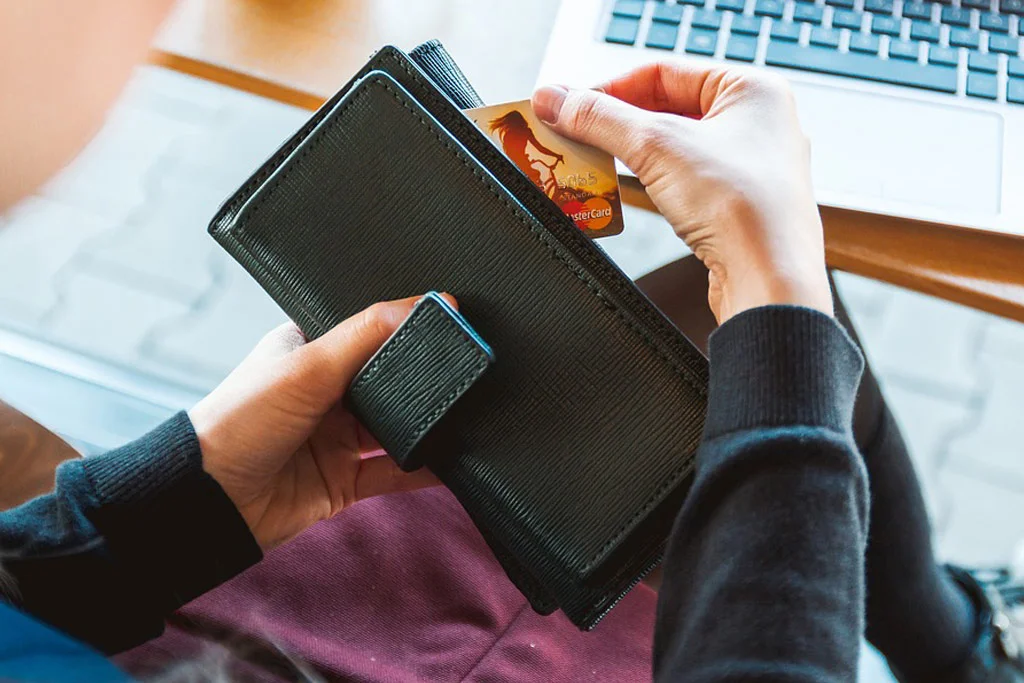 Persona che estrae una carta di credito da una borsa