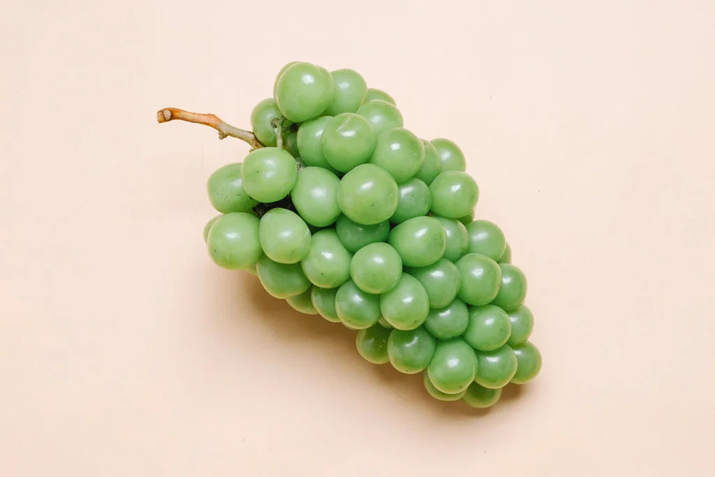 Uva verde su sfondo rosa