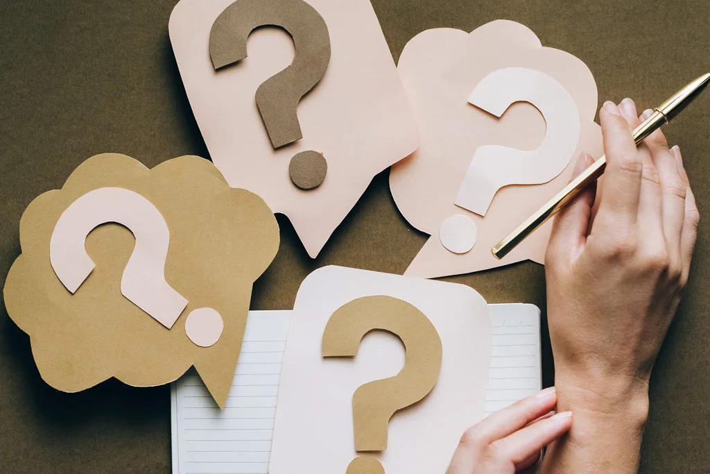 เครื่องหมายคำถามจำนวนมากวางอยู่บนโต๊ะ