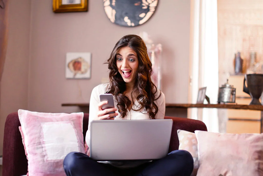 คนที่มีตาเบิกกว้างและตื่นเต้นขณะมองโทรศัพท์อยู่นั้น