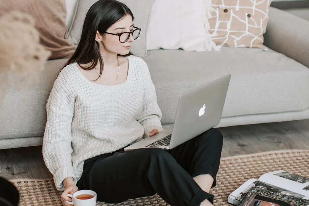 坐在地板上用筆記本電腦工作的人