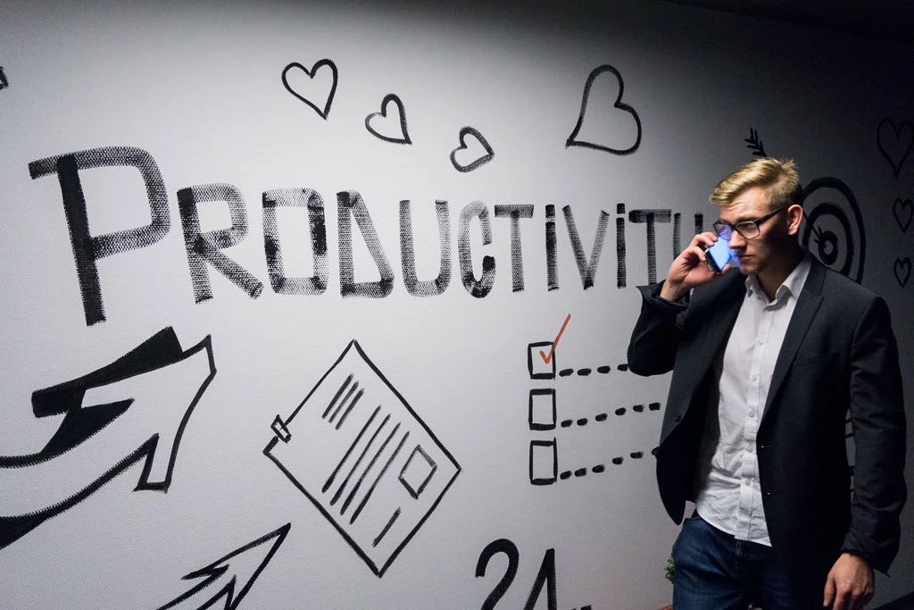 Persona al telefono che parla accanto a un testamento con scritto Produttività in grassetto sopra