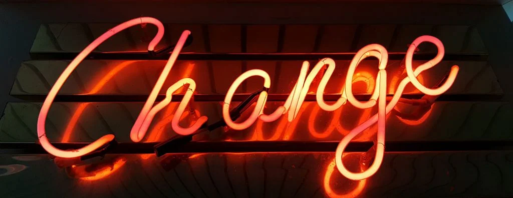 Insegna al neon che dice cambia