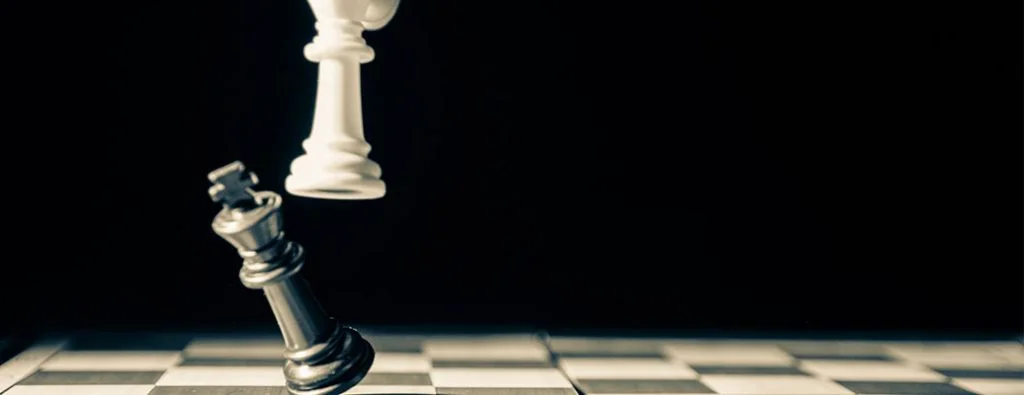 un re della dama che viene rovesciato su una scacchiera