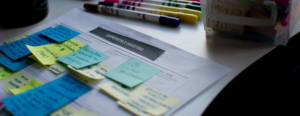 pezzo di carta con un mazzo di foglietti adesivi attaccati ad esso