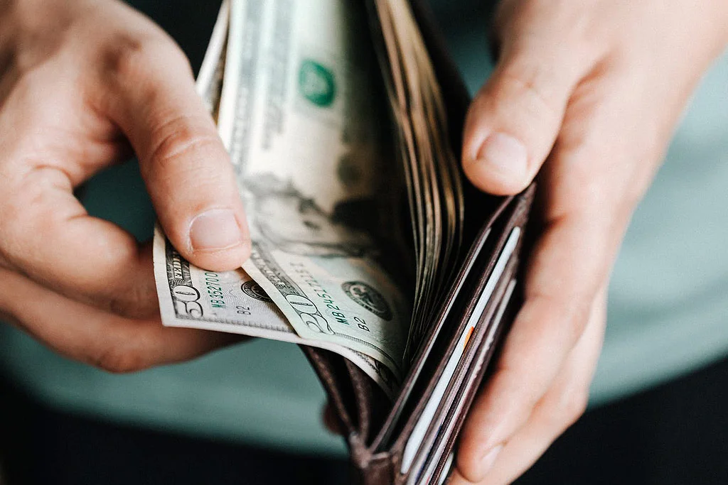 お金が入った財布を開ける人