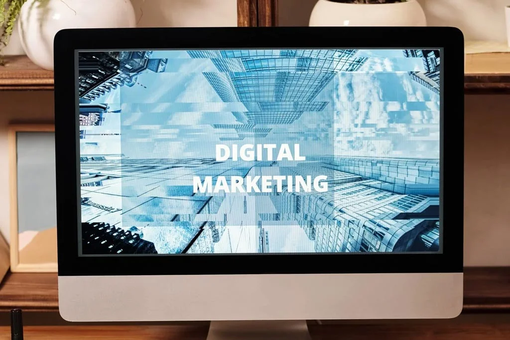 背景としてグラフィックと画面を横切って行くデジタルマーケティングの言葉とコンピュータ画面