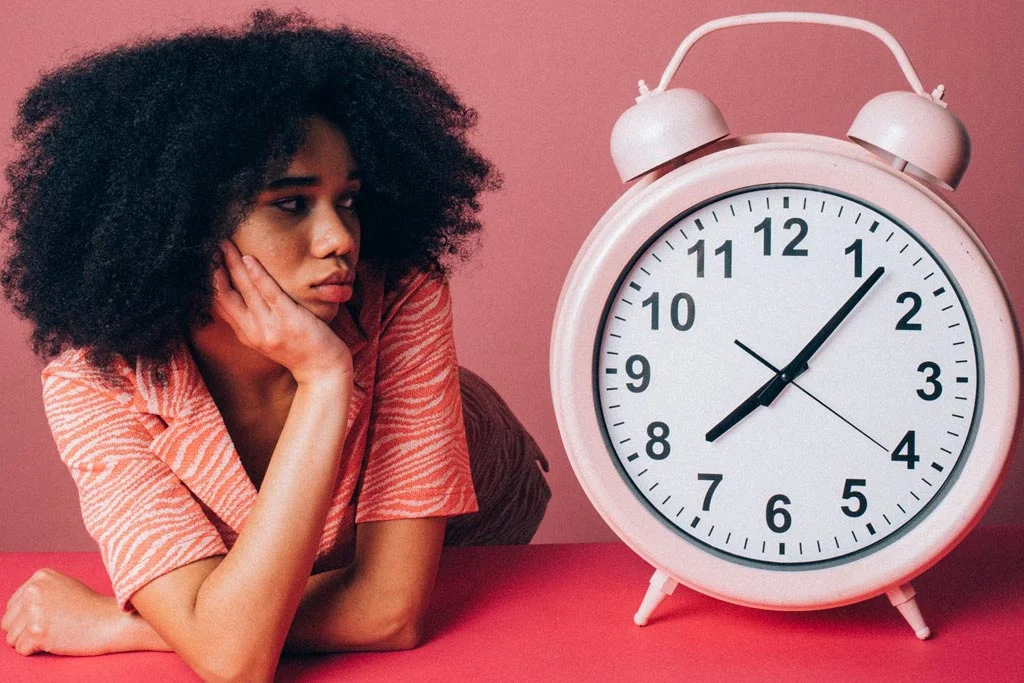 特大の目覚まし時計を見ている人