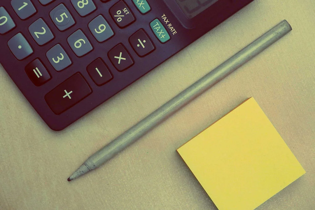 電卓の鉛筆と机の上の付箋