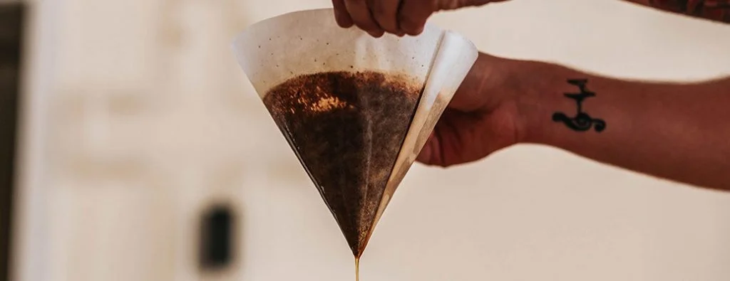 コーヒーフィルターでコーヒーをろ過している人