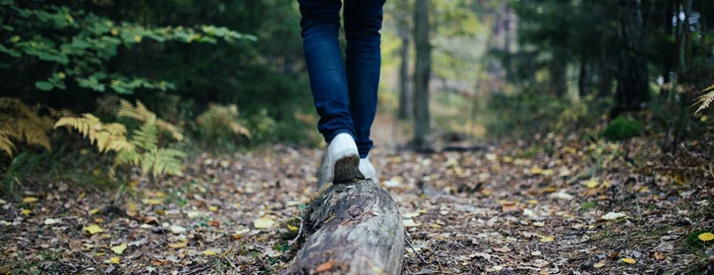 seseorang berjalan dan menyeimbangkan di atas balok kayu
