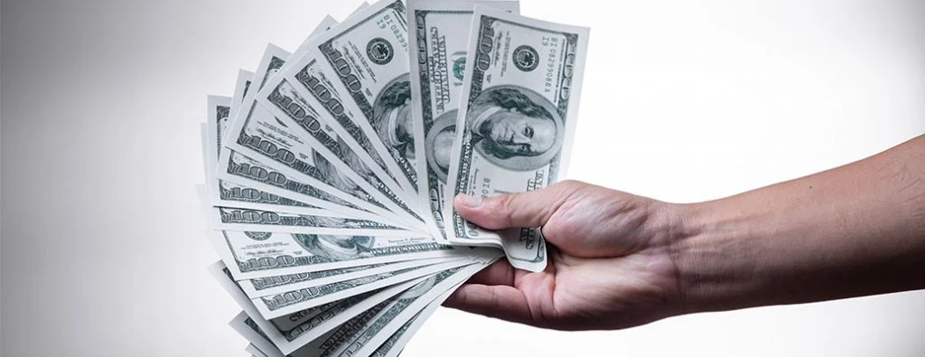 une personne qui détient de l'argent en éventail