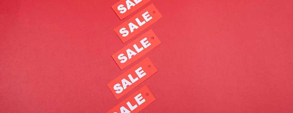 un tas d'étiquettes de vente alignées sur une table rouge