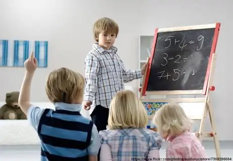 다른 사람에게 수학을 가르치는 아이