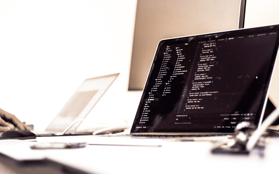 laptop dengan coding di layar