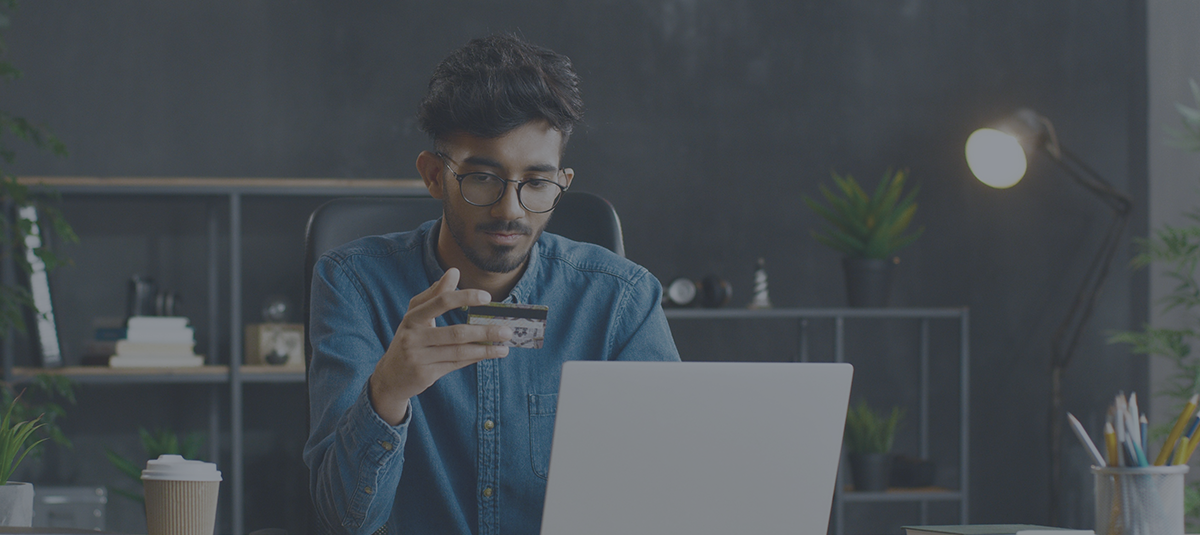 man in blue يقوم بالدفع عبر الإنترنت ببطاقة ائتمان