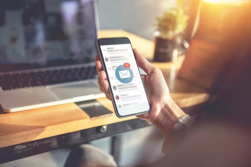 BIMIパート2ヘッダー画像-未開封のメールで自分の携帯電話を見ている女性