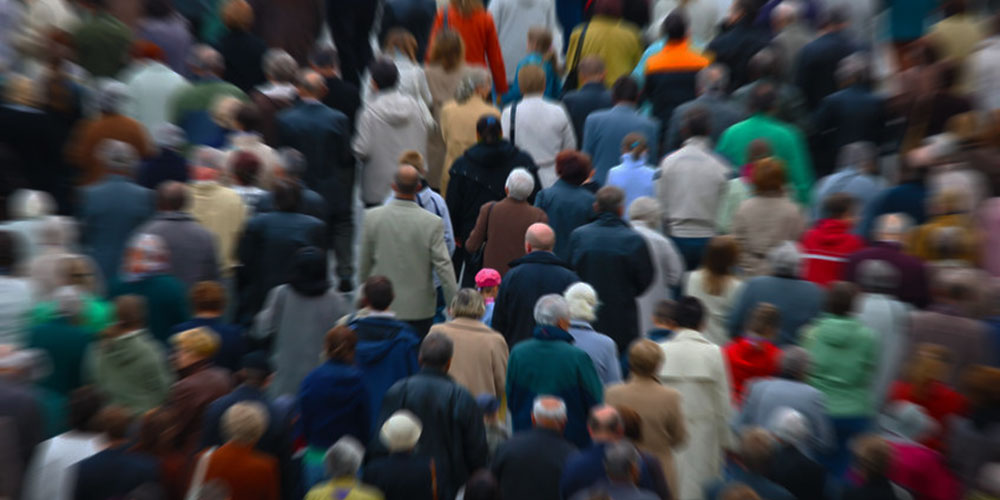 حشد مزدحم من الناس يمشون في المدينة