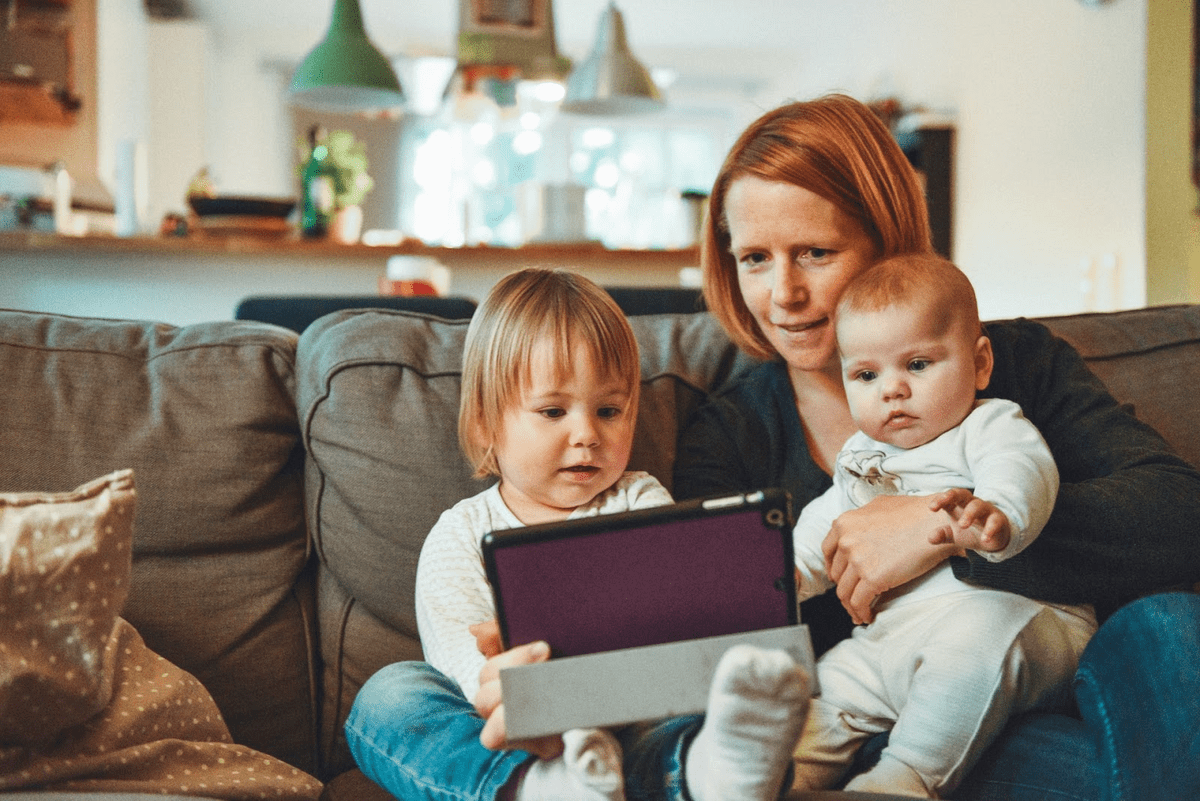Femme lisant sa tablette avec des enfants.