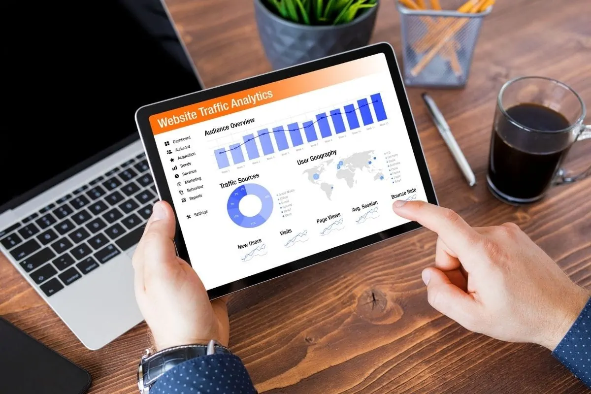 タブレットでウェブサイトのトラフィック分析をスクロールしている人。