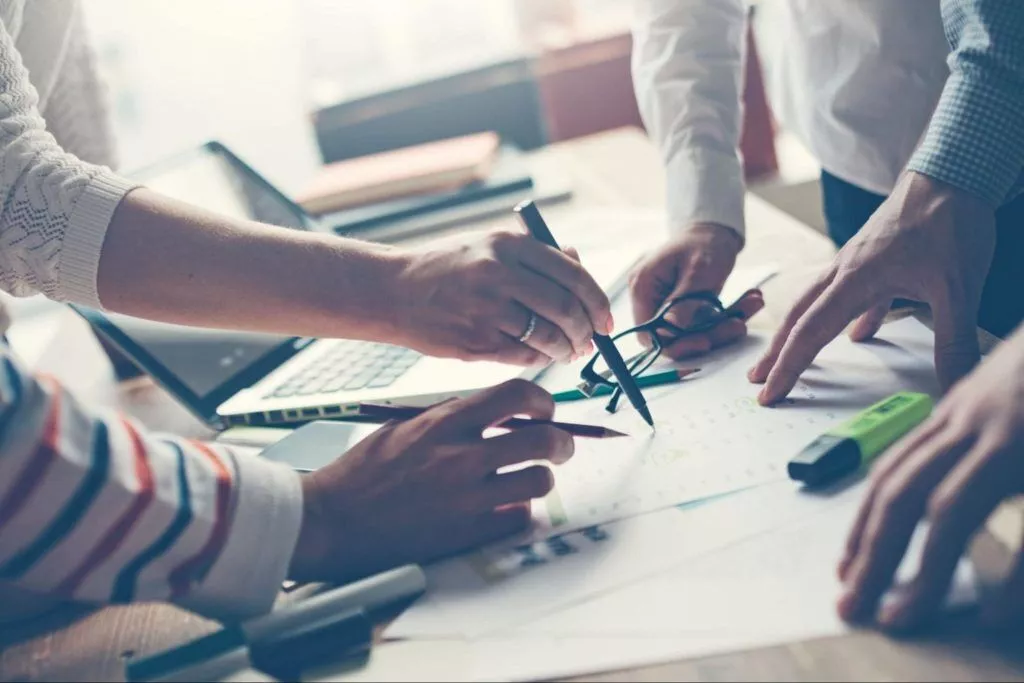 Un grup de oameni care colaborează și analizează date