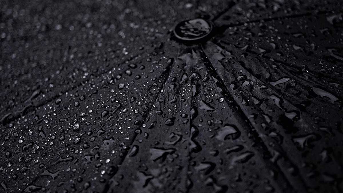 le gocce di pioggia sull'ombrello nero evocano tristezza.