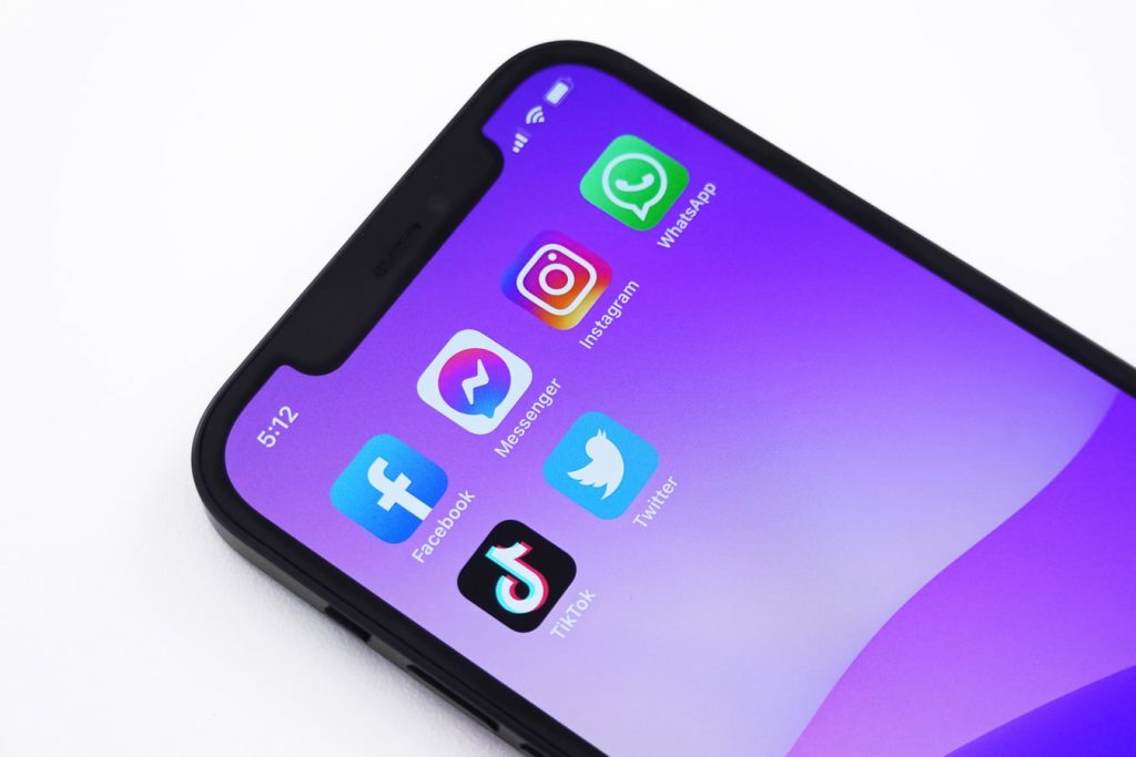 iPhone con fondo morado y varias aplicaciones de redes sociales