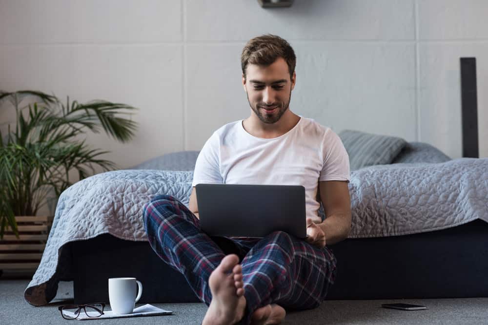 침실에서 집에서 일하는 남자