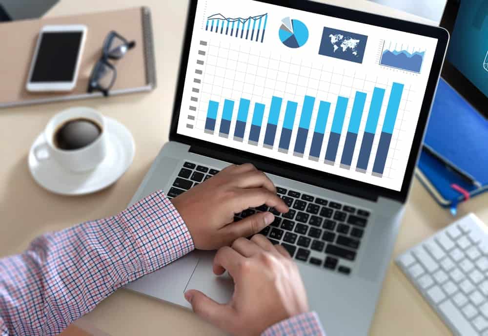 一台打開的筆記本電腦，屏幕上有圖形和圖表。