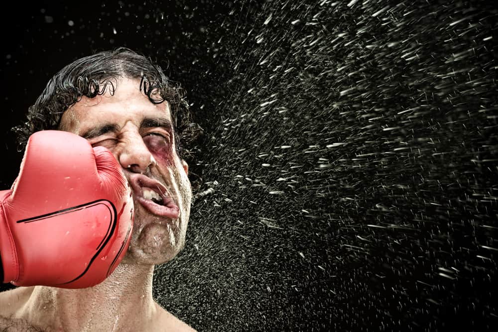 顔を殴られる男