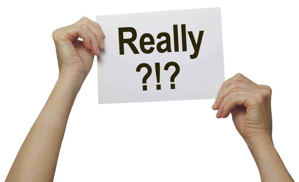 Mains tenant un papier avec du texte "Vraiment ?!?".