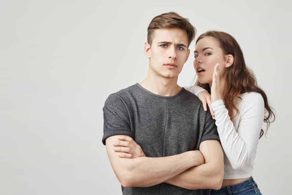 Uma mulher sussurrando para o homem.