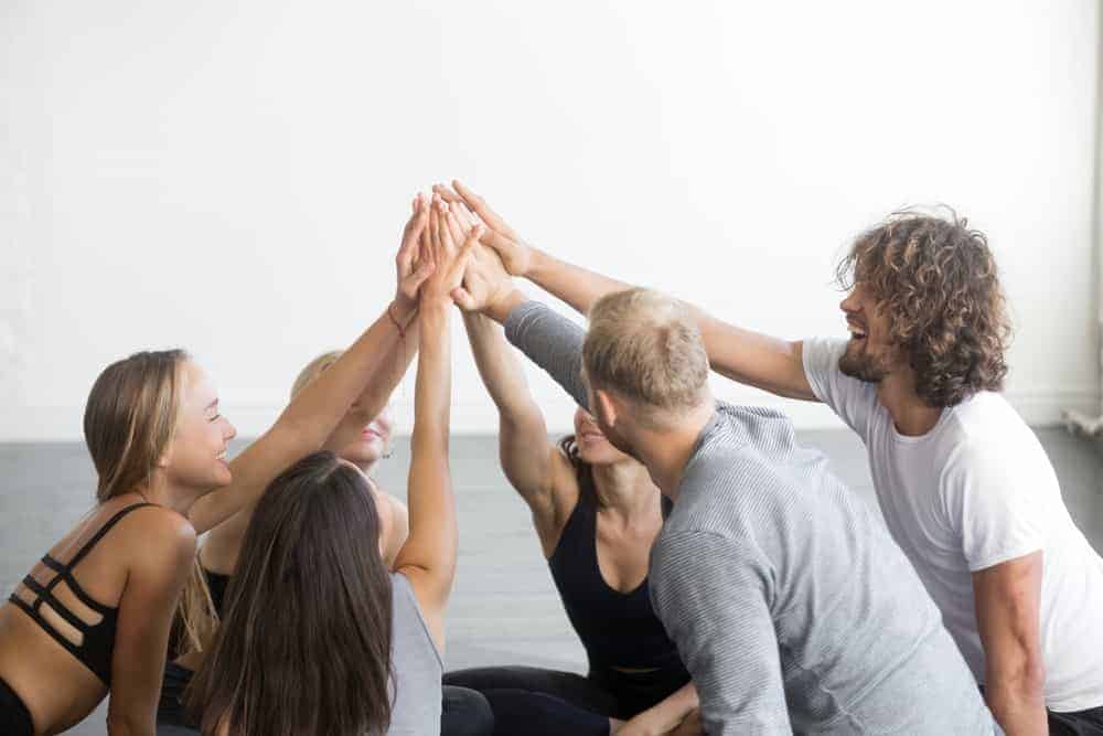 Un groupe d'amis faisant un high five en signe de travail d'équipe.