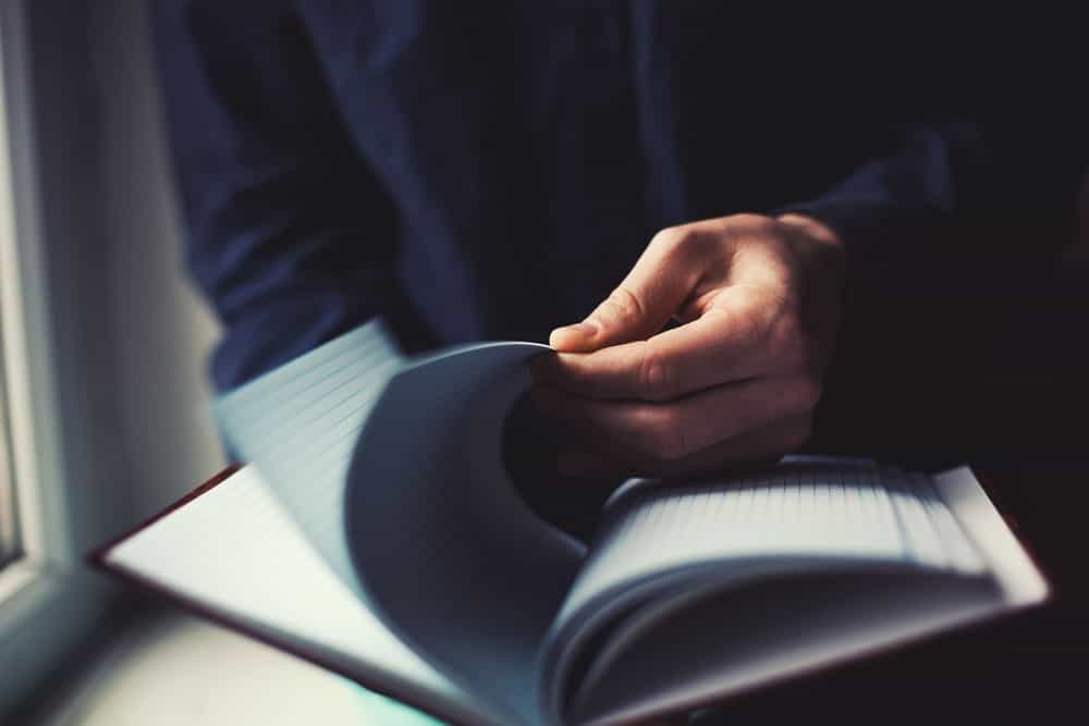 빈 공책의 페이지를 넘기는 남자.