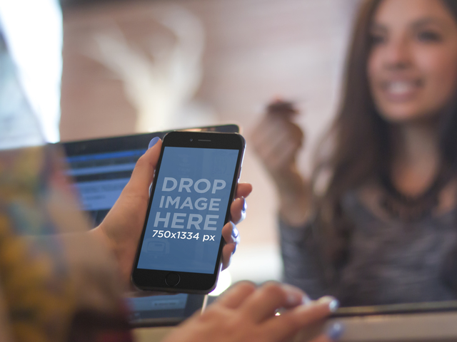 黒の iPhone 6 を使用して支払い場所を取得するキャッシャーのモックアップ ステージ イメージ