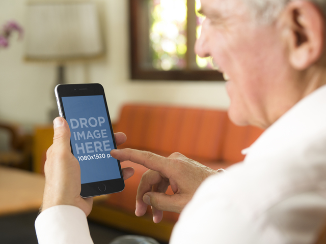 Шаблон макета пожилого мужчины с iPhone 6 Plus дома Placeit Stage Image