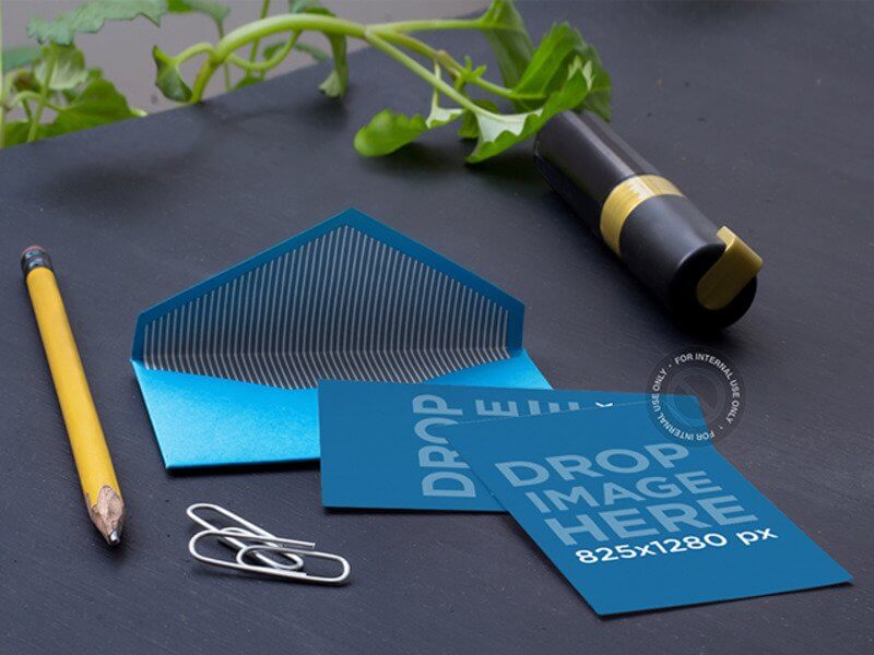 MOCKUP OF AN OPEN ENVELOPE LYING NEXT TO SOME OFFICE SUPPLIES