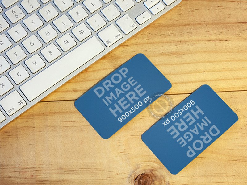 MOCKUP OF TWO BUSINESS CARDS LYING ON TOP OF A DESK AT AN OFFICE