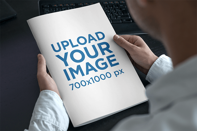 파란 셔츠를 가진 남자의 손에 잡지의 모형