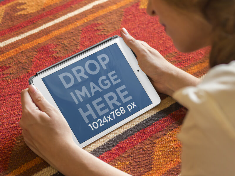 Maquette de fille utilisant un iPad blanc posé sur le tapis