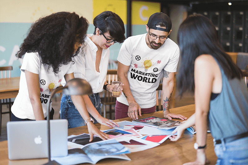 Équipe de collègues portant une maquette de t-shirts à col rond lors d'un brainstorming
