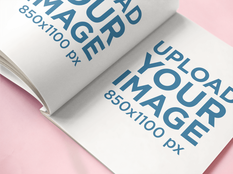 Magazine ouvert allongé sur une maquette de surface rose