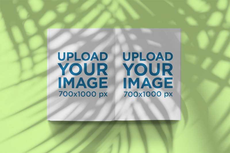 Maquette d'un magazine ouvert sous une ombre de palmier